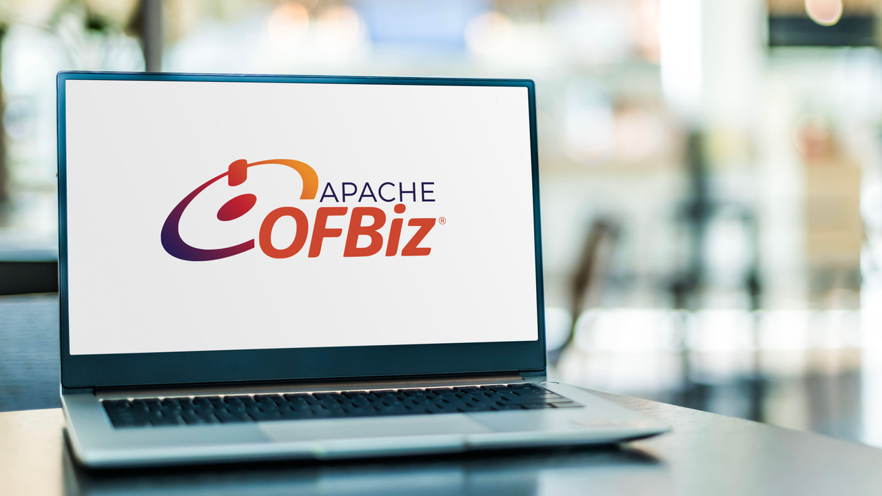 A laptop on a counter with the Apache OFBiz logo on its screen